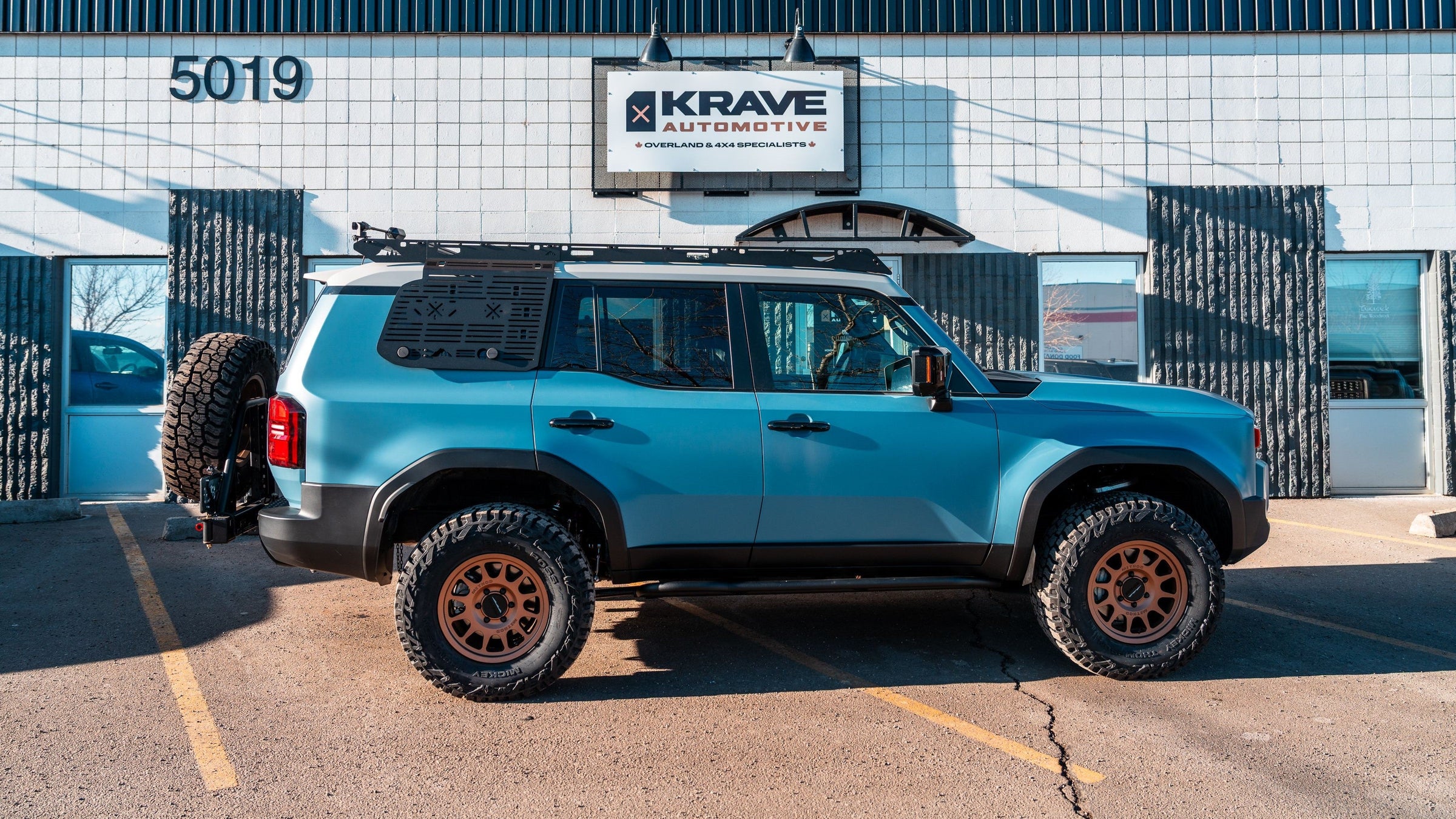 2024 Toyota Land Cruiser 250 off-road and overland build with suspension lift, bronze wheels, roof rack and rear swing-out spare tire